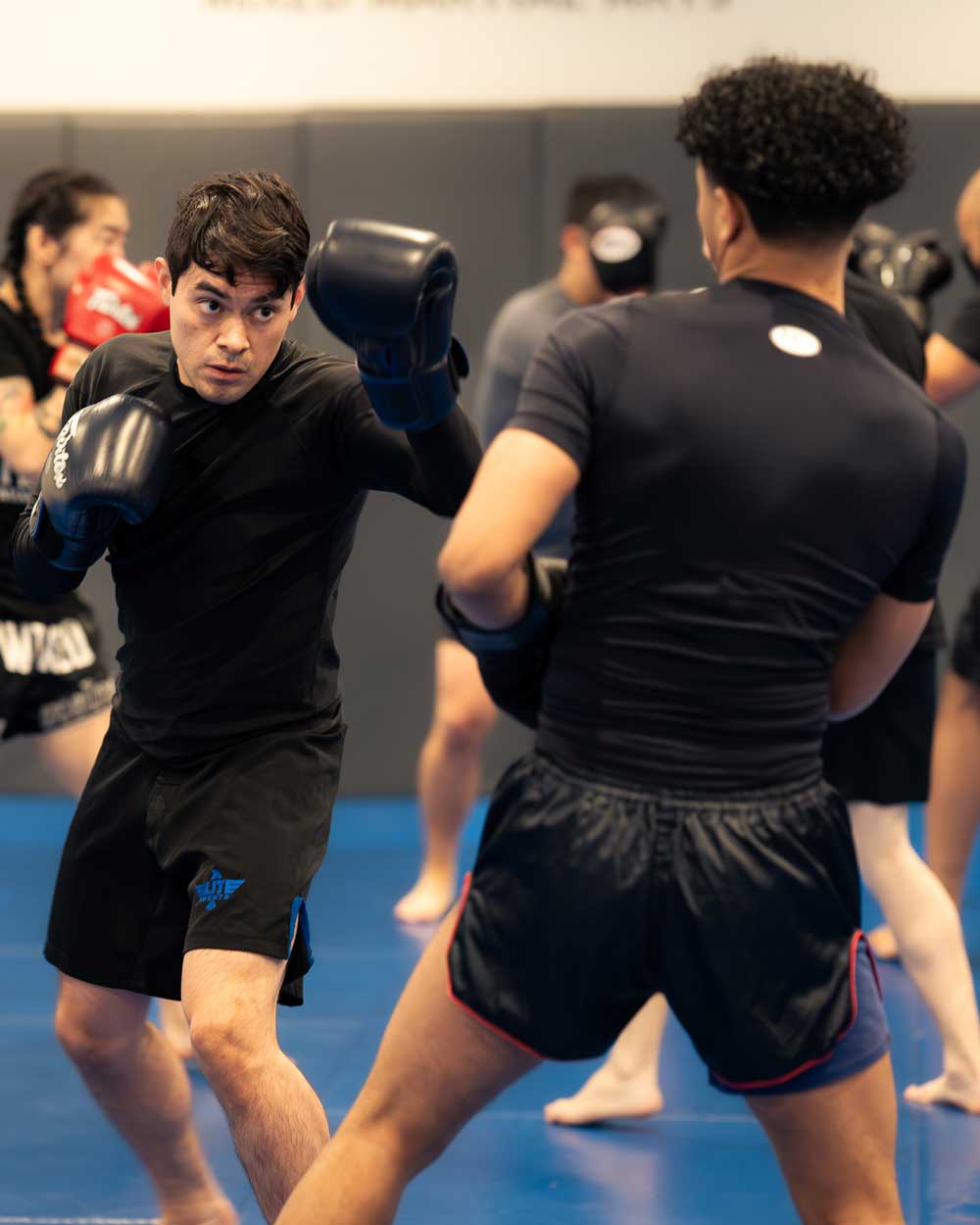 Two guys sparring, one throwing a punch