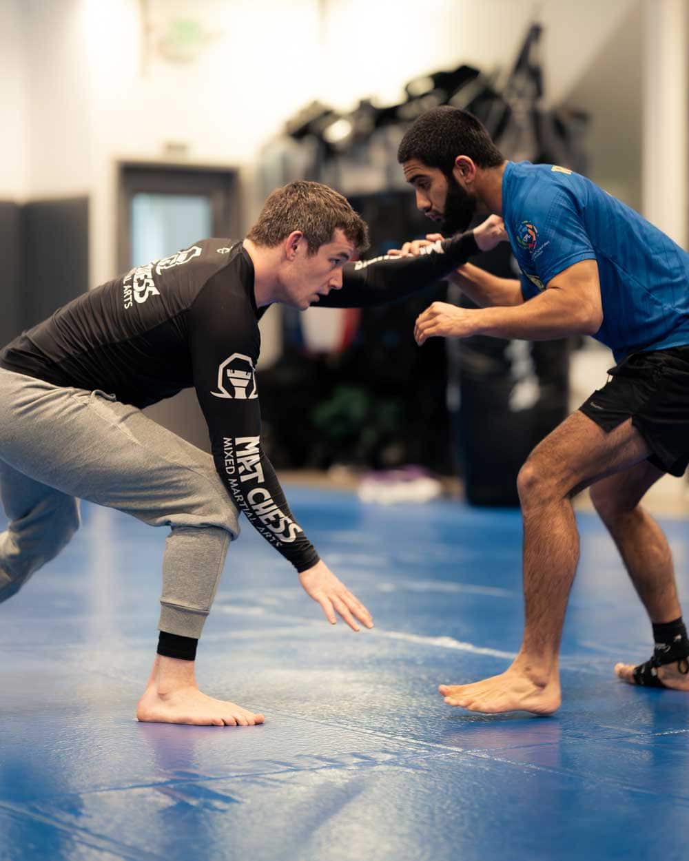 Two guys in a jiu-jitsu match, crouched and ready to grapple